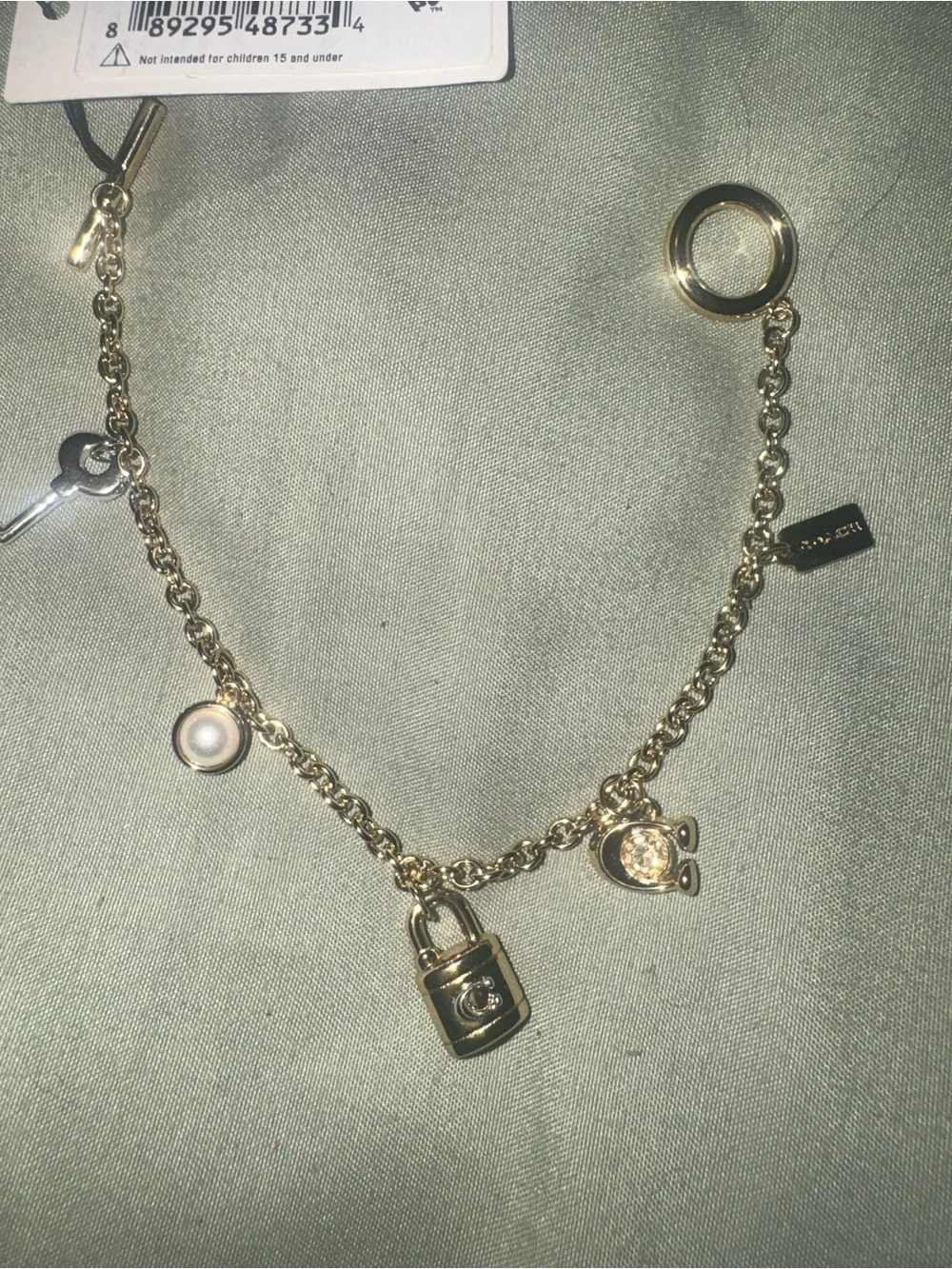 Coach Gold tone Charm Bracelet with Padlock, Key and Pearl Accents CD855 A31